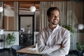 Happy motivated young hispanic businessman posing in modern office.