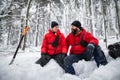 Happy mountain rescue service on operation outdoors in winter in forest, digging snow with shovels. Royalty Free Stock Photo