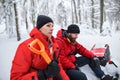 Happy mountain rescue service on operation outdoors in winter in forest, digging snow with shovels. Royalty Free Stock Photo