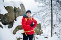 Happy mountaineer reaches the top of a mountain. He is holding an ice ax.