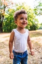 Happy mulatto or afro boy child smiling in park