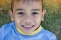 Happy mulatto boy child is smiling enjoying adopted life. Portrait of young boy in nature, park or outdoors. Concept of happy