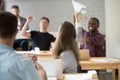 Happy multi-ethnic business team launching paper planes in cowor