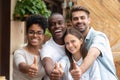 Happy multi-ethnic friends group showing thumbs up looking at camera