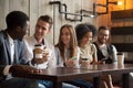 Happy multi-ethnic group of friends talking using smartphones at Royalty Free Stock Photo