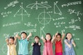 Multi-ethnic group of school children standing in classroom with math concept Royalty Free Stock Photo