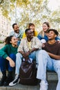 Happy multi-ethnic young diverse hipster student friends hanging out outdoors. Royalty Free Stock Photo