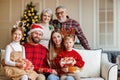 Happy multi generation family celebrating New Year or Christmas Eve together at home near xmas tree Royalty Free Stock Photo