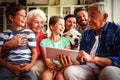 Happy multi-generation family using digital tablet in living room Royalty Free Stock Photo