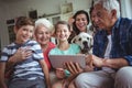 Happy multi-generation family using digital tablet in living room Royalty Free Stock Photo