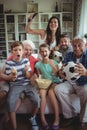 Happy multi-generation family watching soccer match on television in living room Royalty Free Stock Photo