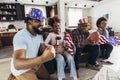 Multi-generation family watching soccer match on television in living room at home Royalty Free Stock Photo