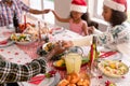 Happy multi generation family wearing santa hats, praying together, having christmas meal Royalty Free Stock Photo