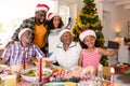 Happy multi generation family wearing santa hats, taking selfie Royalty Free Stock Photo