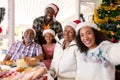 Happy multi generation family wearing santa hats, taking selfie Royalty Free Stock Photo