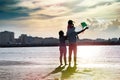 Happy multicultural family with little cute girl on beach enjoying flying a kite. Royalty Free Stock Photo