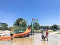 Happy multicultural kids and parent playing at splash park in Texas in post COVID-19 pandemic