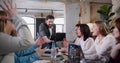 Happy multiethnic business people put hands together as a team with Caucasian boss at loft office meeting slow motion. Royalty Free Stock Photo