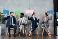 Happy multiethnic businesspeople holding speech bubbles and thought bubble while sitting in Royalty Free Stock Photo