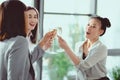 happy multiethnic businesswomen clinking with champagne glasses