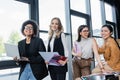 happy multiethnic businesswomen with magazines and