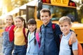 Happy Multiethnic Children Posing Outdoors Near School Bus, Embracing And Smiling Royalty Free Stock Photo