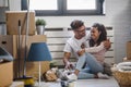 Happy multiethnic couple just moved into new empty apartment unpacking Royalty Free Stock Photo