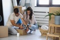 Happy multiethnic couple just moved into new empty apartment unpacking Royalty Free Stock Photo