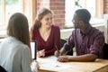 Happy multiethnic couple looking at each other before signing co Royalty Free Stock Photo