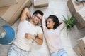 Happy multiethnic couple lying on floor after moving to a new home Royalty Free Stock Photo