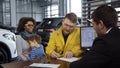 Multiethnic couple buying car in salon Royalty Free Stock Photo