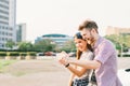 Happy multiethnic couple taking selfie during sunset in the city, fun and smiling, love or gadget technology concept Royalty Free Stock Photo