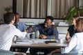 Happy multiethnic coworkers shaking hands over table at corporate meeting Royalty Free Stock Photo