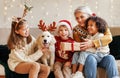 Happy multiethnic family, grandmother with grandchildren and dog enjoying Christmas day