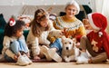Happy multiethnic family, grandmother with grandchildren and dog enjoying Christmas day Royalty Free Stock Photo