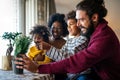 Happy multiethnic family at home taking care for flowers and having fun time together Royalty Free Stock Photo