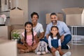 Happy multiethnic family sitting on floor in new home Royalty Free Stock Photo