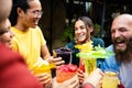 Happy multiethnic group of friends drinking trendy cocktails in a terrace bar Royalty Free Stock Photo