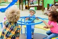 happy multiethnic group of little kids riding on carousel