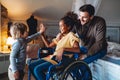 Happy multiethnic family. Smiling little girl with disability in wheelchair at home Royalty Free Stock Photo