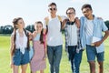 happy multiethnic teenage friends standing together and smiling at camera