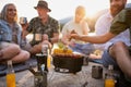 Happy multigeneration family on summer holiday trip, barbecue by lake.