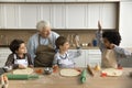 Happy multigenerational family cooking together in cozy domestic kitchen Royalty Free Stock Photo