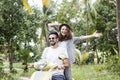 Happy multinational couple traveling on a motorbike in the jungle, honeymoon, vacation, travel concept Royalty Free Stock Photo