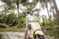 Happy multinational couple traveling on a motorbike in the jungle, honeymoon, vacation, travel concept Royalty Free Stock Photo