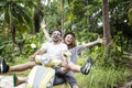 Happy multinational couple traveling on a motorbike in the jungle, honeymoon, vacation, travel concept, friends have fun Royalty Free Stock Photo