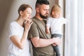 Happy multinational family father young man and mother with baby girl little daughter having fun near window room at home Royalty Free Stock Photo