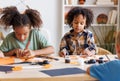 Happy multinational group of children making Halloween home decorations together