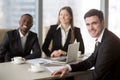 Happy multinational office workers posing at desk