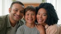 Happy multiracial African American loving mum and dad kissing little boy in cheeks adoption child care family bonding Royalty Free Stock Photo